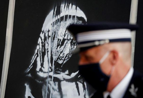 جدارية رسمها فنان الشارع البريطاني بانكسي سرقت من مسرح باتاكلان في باريس خلال مراسم اعادتها في السفارة الفرنسية بروما. تصوير: يارا ناردي-رويترز.